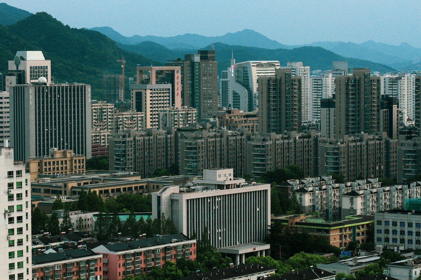 Bloques de viviendas en una ciudad china, con montes al fondo. Alibaba no nació en un garaje, sino en un piso de Hangzhou, con dieciocho socios. Foto: Zhi Gong en Unsplash.